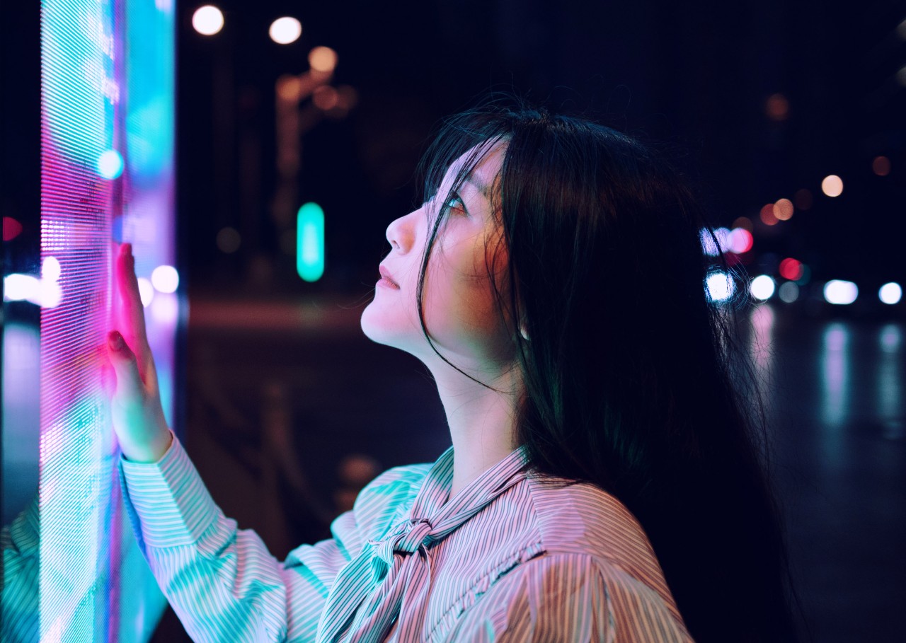 asian woman with her hand on a touchscreen on the street